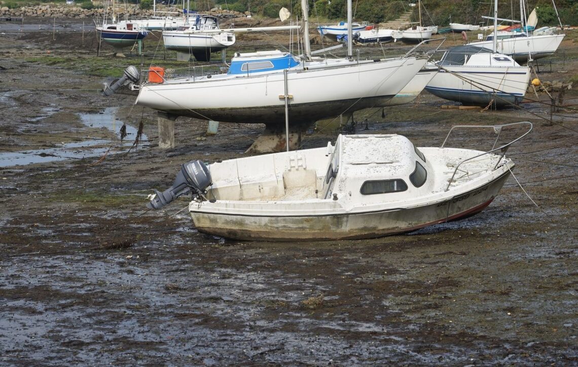 Boote liegen bei Ebbe auf schlammigem Grund im Tidehafen