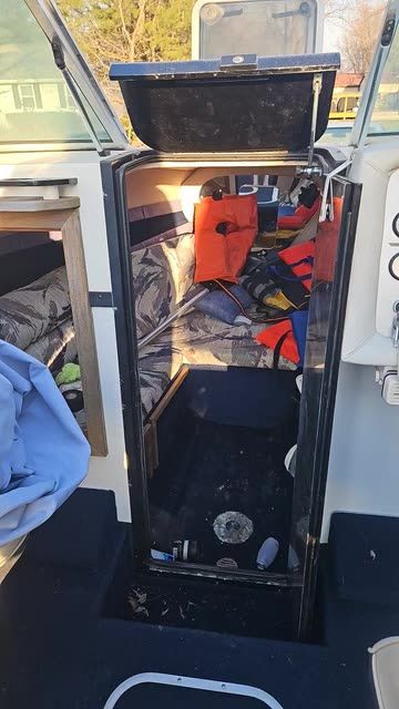 Blick in eine unordentliche Bootskajüte mit Rettungswesten und Textilien.